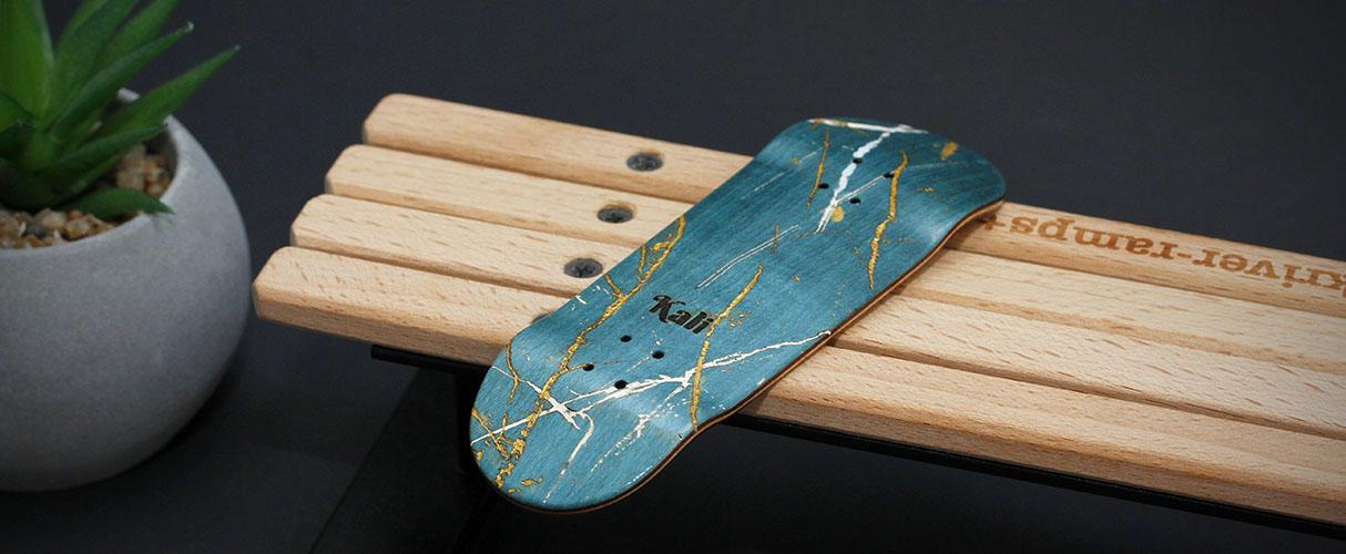Kali Fingerboards deck, engraved and painted turquoise bottom ply, ornated with gold and white details